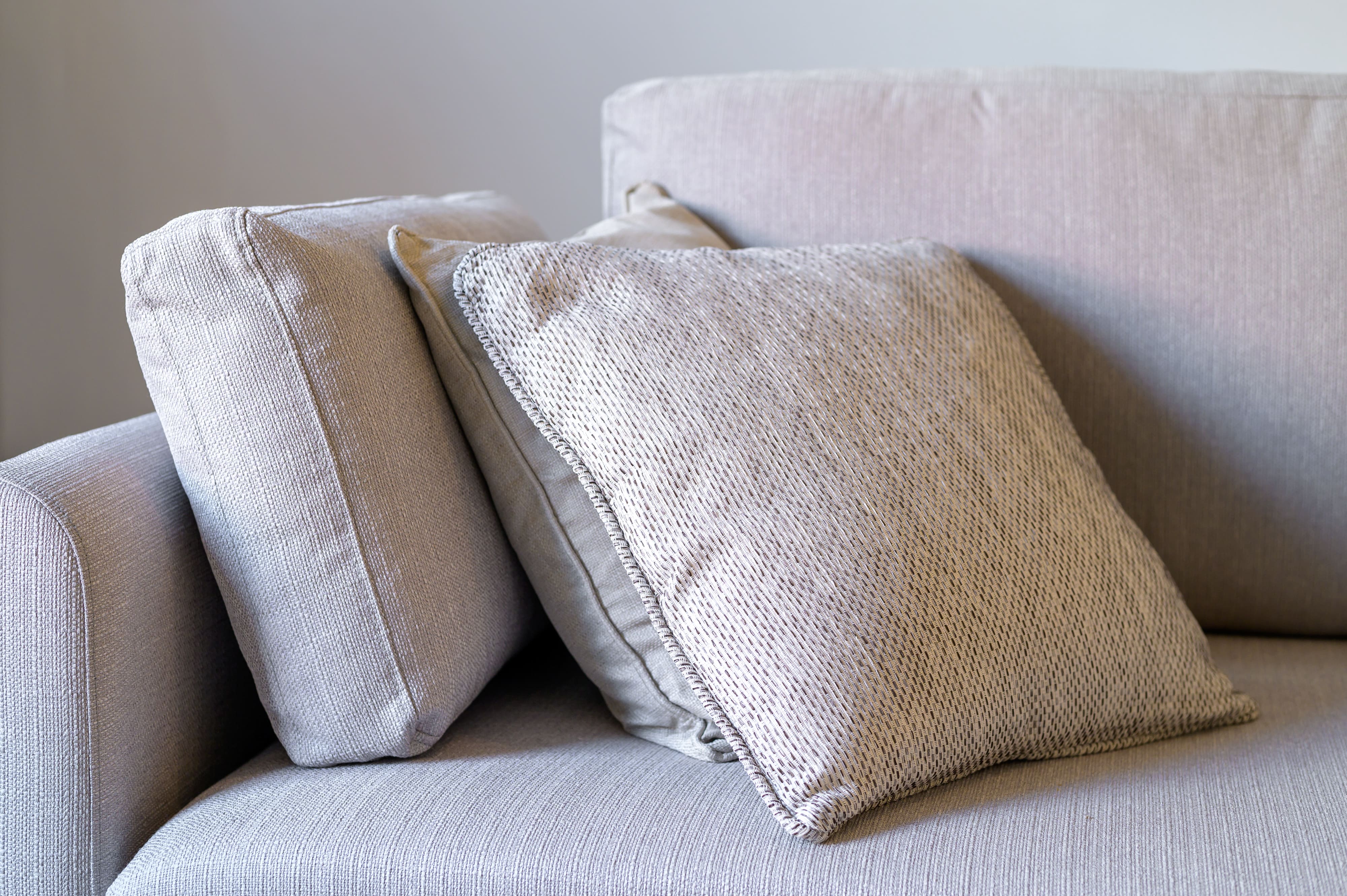 Textured beige cushions arranged on a matching fabric sofa